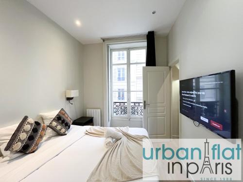 - une chambre avec un lit et une télévision murale dans l'établissement 64 - Urban Luxury Flat near Champs-Elysees, à Paris