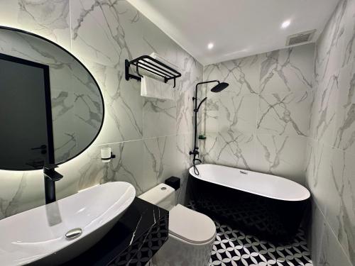 a bathroom with a tub and a sink and a mirror at LION 15 Hotel in Can Tho