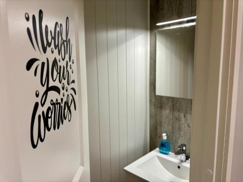 a bathroom with a sink and a mirror at Angelas White House - single room in Stamsund