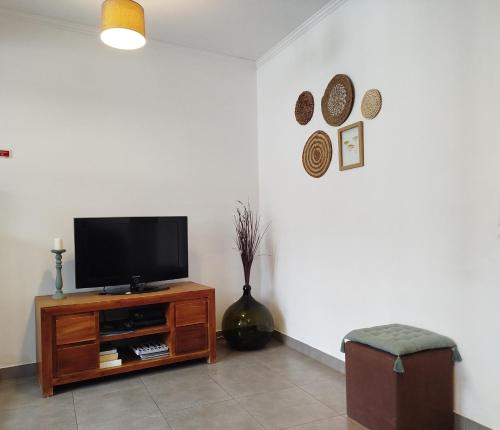 a living room with a flat screen tv on a stand at Casa do Cruzeiro in Lagoa