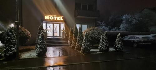 a hotel entrance at night with a sign on it at Hotel Garni Superior in Metzingen