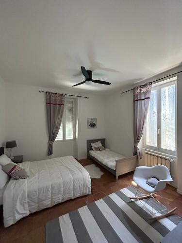 une chambre avec un lit et un ventilateur de plafond dans l'établissement L'Oustalou, à Béziers