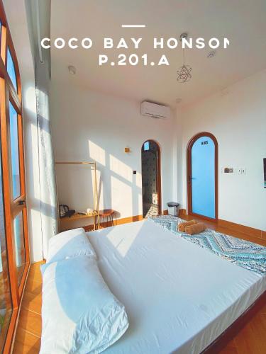 a large white bed in a room with a sign at Coco Bay Hon Son in Lai Sơn