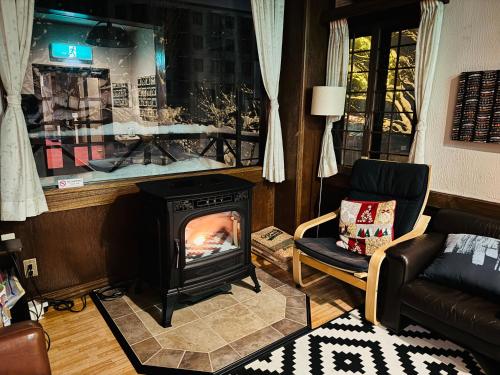 a living room with a fireplace and a couch at Belle Vue Nishiura in Minami Uonuma