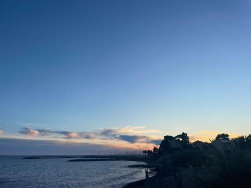 a view of the ocean with a sunset in the background at Bistrot del mare in Santo Stefano al Mare