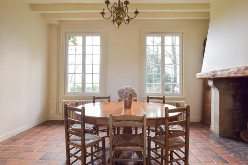 une salle à manger avec une table et des chaises en bois dans l'établissement Le Domaine de Flancourt, 45min de Deauville, à Flancourt-Crescy-en-Roumois