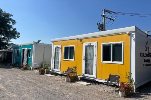 a row of mobile homes parked in a parking lot at Kua Car Camp in Lampang