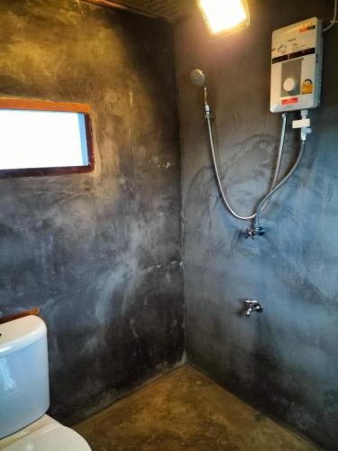 a bathroom with a shower and a toilet at Bunnum Homestay in Ban Mae Tap