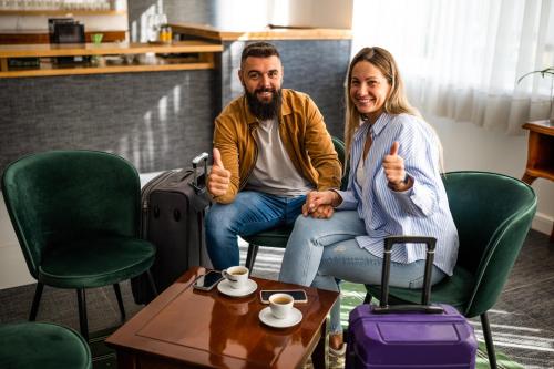 a man and a woman sitting in chairs giving thumbs up at Hotel Mio City in Kula