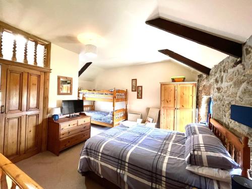 a bedroom with a bed and a desk and a tv at Annie's Cottage - 3 miles from the iconic Minack Theatre in Saint Buryan
