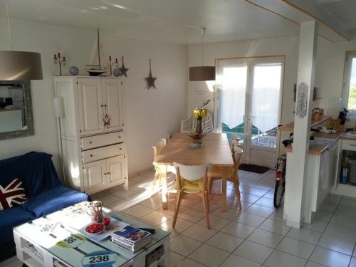 un salon avec une table et une cuisine dans l'établissement Maison 2 chambres, centre-ville, jardin sud, proche plage - STELLA PLAGE - FR-1-236-76, à Stella-Plage