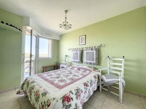un dormitorio con una cama y una silla en Appartement 1 Chambre + Cabine avec Vue sur Mer & Dunes, 3ème Étage avec Ascenseur - FR-1-236-73, en Stella-Plage