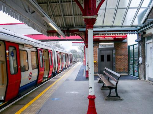 a train station with a bench and a train at Pass the Keys Amersham Station Road Studio in Amersham