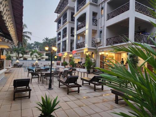 a patio with tables and chairs in front of a building at Coastal Suites Apart Hotel ---- 8 minutes walk to beach in Benaulim