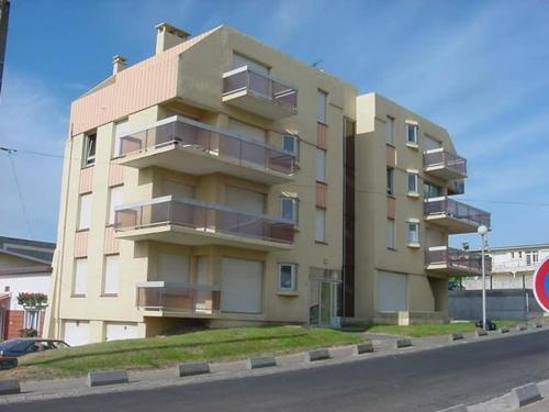un grand immeuble situé sur le côté d'une rue dans l'établissement Appartement à 50m de la plage avec balcon, animaux acceptés - FR-1-236-64, à Stella-Plage