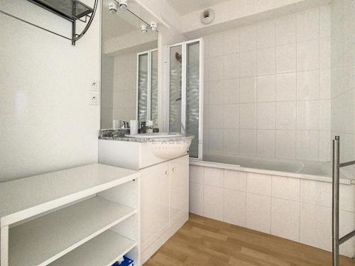 a white bathroom with a sink and a tub at Appartement 2 chambres proche mer et centre, parking inclus - FR-1-236-66 in Stella-Plage