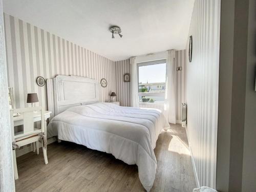 ein weißes Schlafzimmer mit einem Bett und einem Fenster in der Unterkunft Appartement 3 chambres près de la mer à Stella Plage - FR-1-236-126 in Stella-Plage