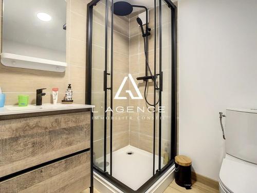 une douche avec une porte vitrée dans une salle de bain dans l'établissement Maison 3 chambres avec terrasse, animaux admis, parking - FR-1-236-132, à Merlimont