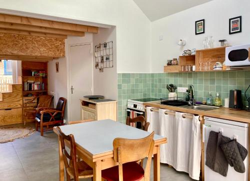une cuisine avec une table et une cuisine avec du carrelage vert dans l'établissement La Petite Maison, à Guérande