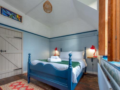 a blue bedroom with a bed with a blue headboard at Pass the Keys Stay in the Original Home of the Gingerbread Man! in Market Drayton