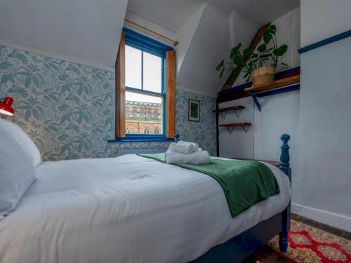 a bedroom with a large white bed with a window at Pass the Keys Stay in the Original Home of the Gingerbread Man! in Market Drayton