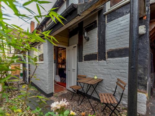a table and chairs sitting outside of a house at Pass the Keys Stay in the Original Home of the Gingerbread Man! in Market Drayton