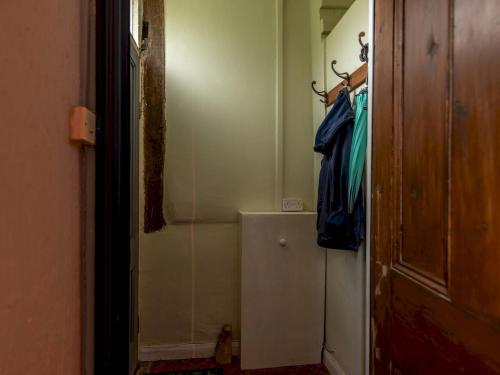 a hallway of a bathroom with a closet and a robe at Pass the Keys Stay in the Original Home of the Gingerbread Man! in Market Drayton