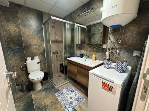 ein Badezimmer mit Toilette, Waschbecken und Dusche in der Unterkunft Mamma Mia in Skopje