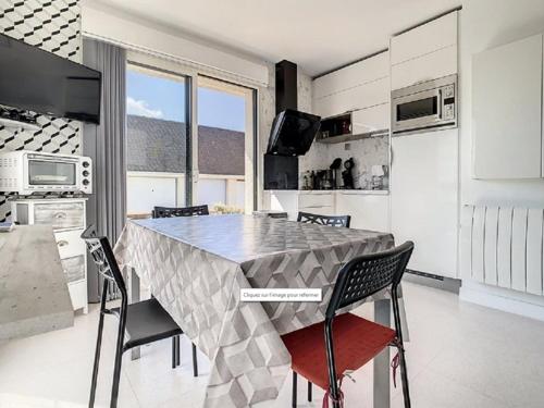 une cuisine avec une table et des chaises dans une pièce dans l'établissement Charmant T2 à Stella-plage, proche mer, tout confort - FR-1-236-147, à Cucq