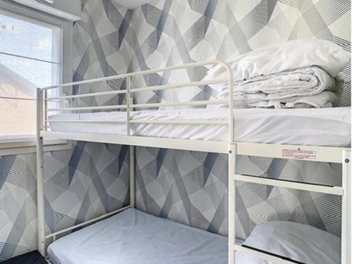 a bunk bed in a room with a geometric wallpaper at Charmant T2 à Stella-plage, proche mer, tout confort - FR-1-236-147 in Cucq