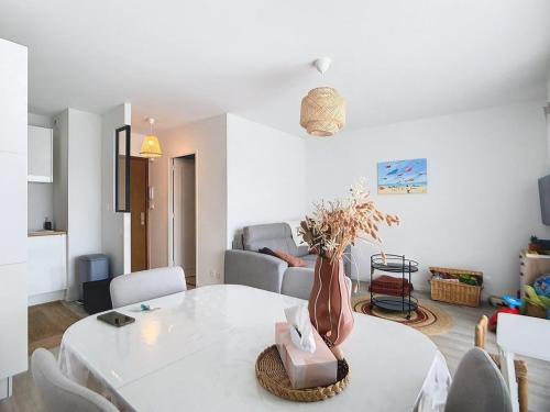 - un salon avec une table blanche et un vase dans l'établissement Appartement cosy pour 4, à 2 pas de la plage avec balcon ! - FR-1-236-161, à Cucq