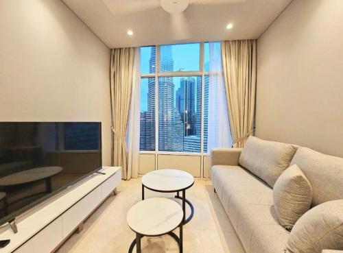 a living room with a couch and a large window at Sky Suites KLCC by KD Luxury Suites in Kuala Lumpur
