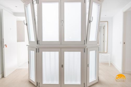 a room with glass doors in a white room at Villalobos by Cadiz Time in Cádiz
