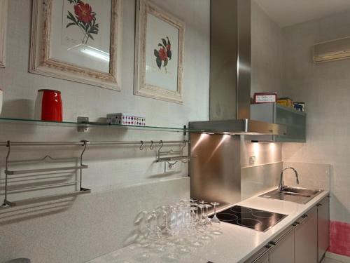 une cuisine avec évier et comptoir avec verres à vin dans l'établissement proche au Palais, à Cannes