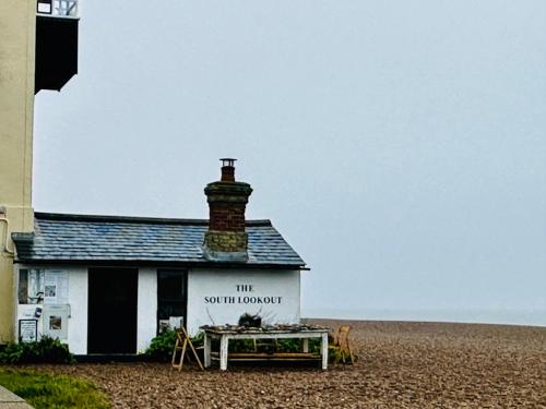 a building with a sign on it on the beach at Chez Ana in Saxmundham