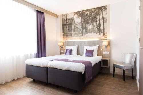 a bedroom with a large bed and a chair at Best Western City Hotel Woerden in Woerden