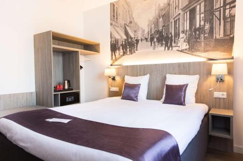 a hotel room with a large white bed with a picture on the wall at Best Western City Hotel Woerden in Woerden