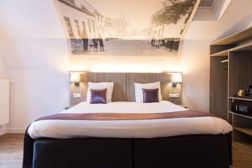 a bedroom with a large bed with a painting on the wall at Best Western City Hotel Woerden in Woerden