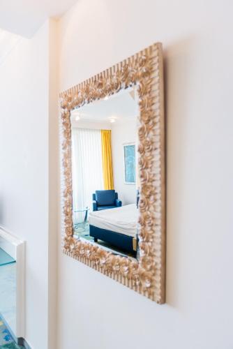 a mirror on a wall with a bed in a room at Vitalia Seehotel in Bad Segeberg
