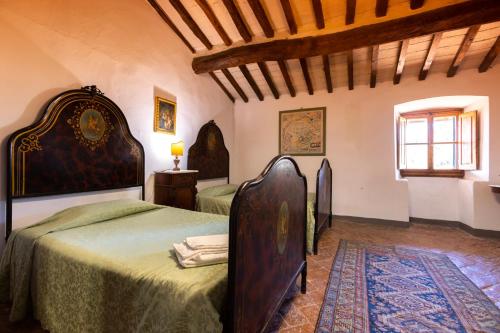 a bedroom with two beds with green sheets and a window at Fattoria Poggio Capponi in Montespertoli