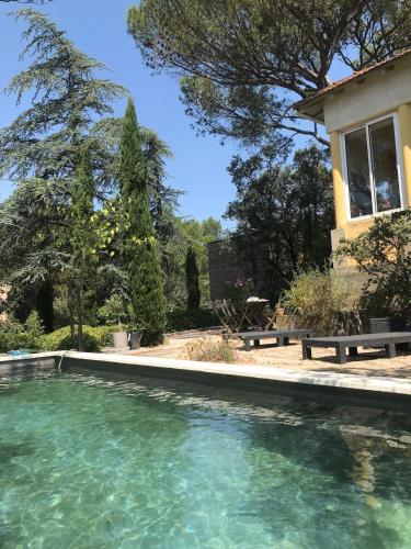 une piscine d'eau en face d'une maison dans l'établissement Maison en bord de garrigue, à Villeneuve-lès-Avignon