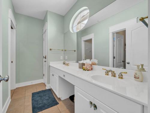 a white bathroom with a sink and a mirror at Penthouse Paradise Condo at Seacrest in Rosemary Beach
