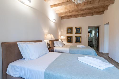 a bedroom with two beds with blue sheets at Origine Country Farm in Tabiano