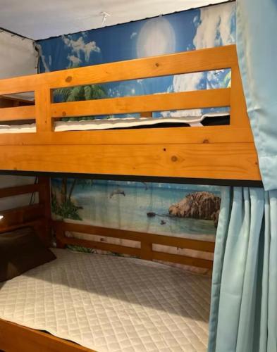 a bunk bed with a painting of a beach at Minato Hostel in Yokohama