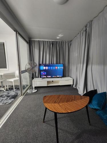 a living room with a tv and a table at Entire Studio Apartment - self check-in in Clontarf