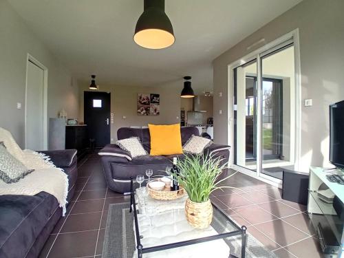 un salon avec un canapé et une table dans l'établissement Saint Palais sur Mer - MAISON récente TOUT CONFORT - WIFI - au calme, à Saint-Palais-sur-Mer