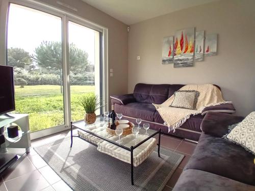 un salon avec un canapé et une table en verre dans l'établissement Saint Palais sur Mer - MAISON récente TOUT CONFORT - WIFI - au calme, à Saint-Palais-sur-Mer