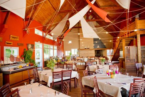 un restaurant avec des tables et des chaises dans une salle dans l'établissement VTF Ker Belen, à Riec-sur-Bélon