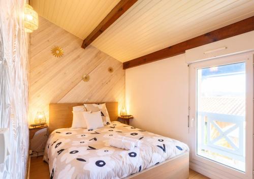 une chambre avec un lit et une grande fenêtre dans l'établissement Maison des Embruns, à Biscarrosse