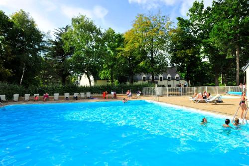 a swimming pool with people in the water at VTF Ker Belen in Riec-sur-Bélon